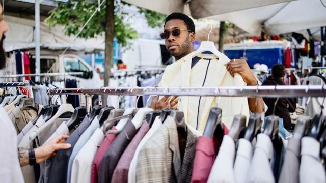 Homem testando roupa de segunda mão