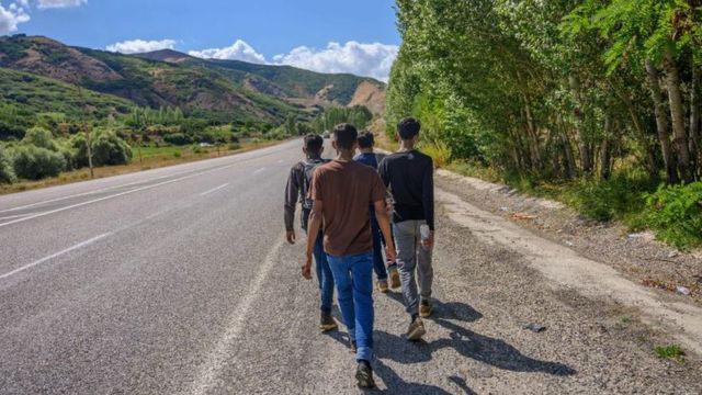 Migrantes caminhando pela estrada no norte do Irã em direção à fronteira com a Turquia