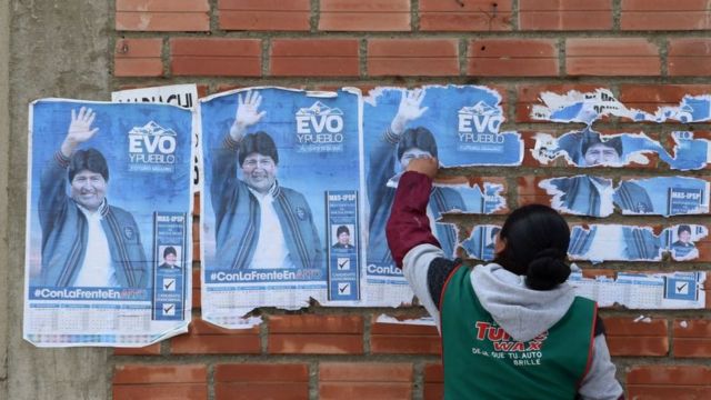 Una mujer frente a carteles de Evo MNorales