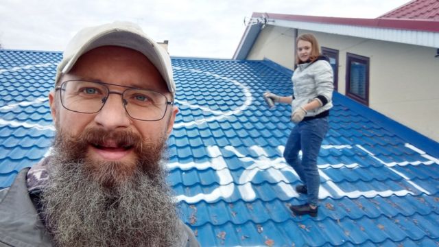 Дмитрий Скурихин с дочерью рисуют пацифик на крыше магазина