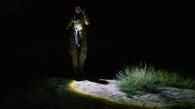 agente de fronteira patrulha área no texas à noite com lanterna