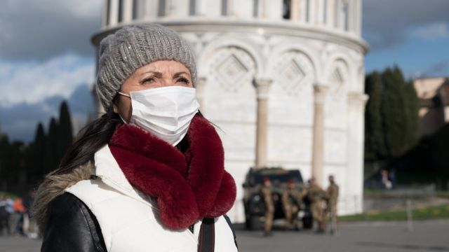 Imagem de uma turista com máscara