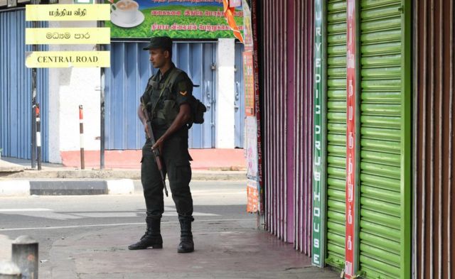 Un soldado srilankés hace guardia frente a un conjunto de tiendas cerradas en Batticaloa.