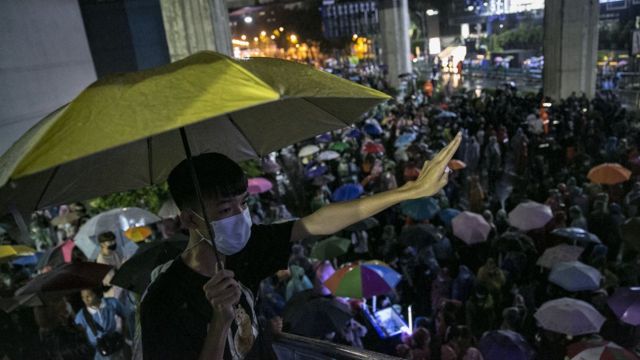 A protester raises three fingers, symbolizing the anti-government movement in Thailand