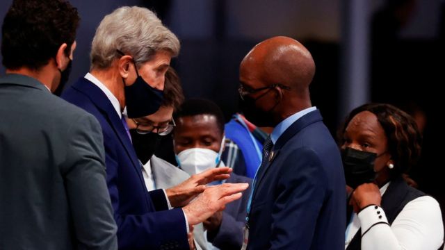 U.S. Climate Ambassador John Kerry speaks with a delegate on COP26