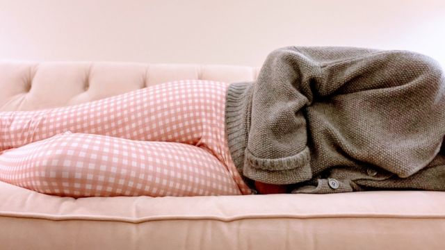 A photo of a woman lying on a sofa