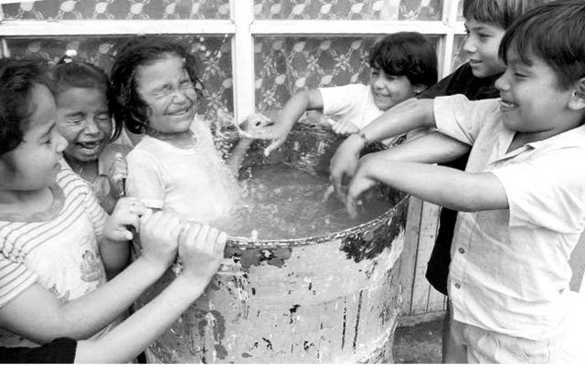 Niños jugando con agua. Foto de archivo: 1993.