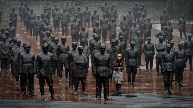 遊客在成都建川博物館的1931-1945年抗日戰爭紀念碑前走過中國領導人和士兵的雕像。