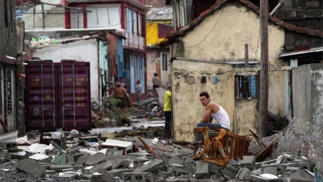 Un hombre sentado sobre los escombros en Baracao
