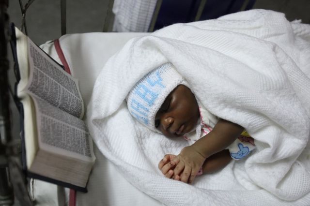 Menina dorme ao lado de uma Bíblia em hospital de Lagos, cidade mais populosa da Nigéria, país profundamente religioso