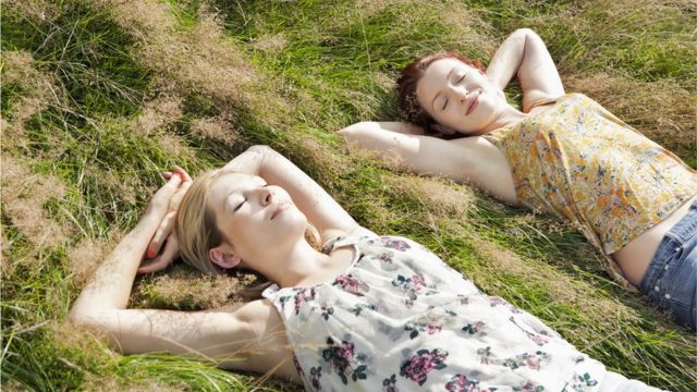 Mulheres tomando sol em gramado