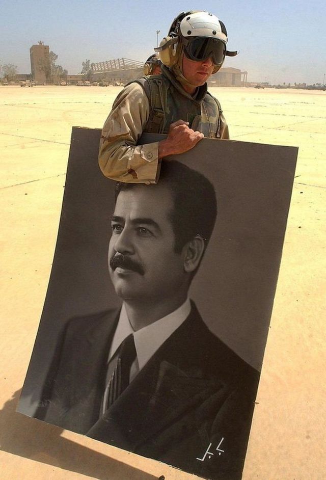 Mwanajeshi akibeba picha ya Saddam Hussein