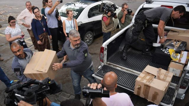 Jornalistas acopmanham retirada de caixas, por policiais civis, com materiais usados nas investigações sobre o caso Marielle
