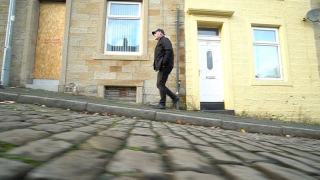 Mick Fleming caminando por las calles de Burnley.