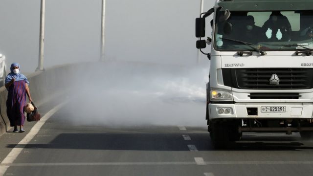 женщина, идущая по шоссе, по струей из грузовика