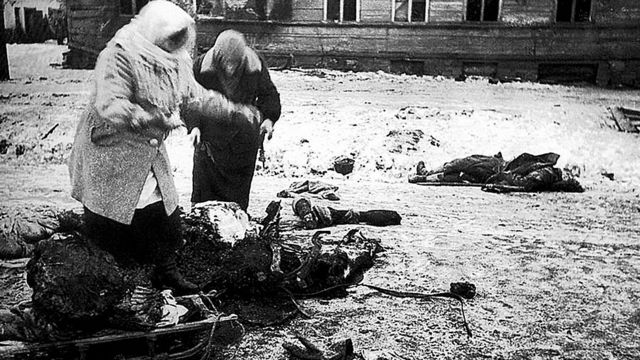Dos figuras femeninas recogen los restos de un caballo muerto para comer, durante el asedio de Leningrado.