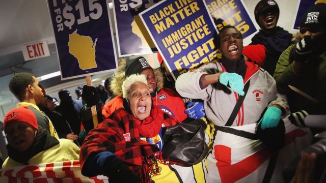 黒人の不当な扱いに抗議する団体が、討論会会場で最低賃金の引き上げを求めた