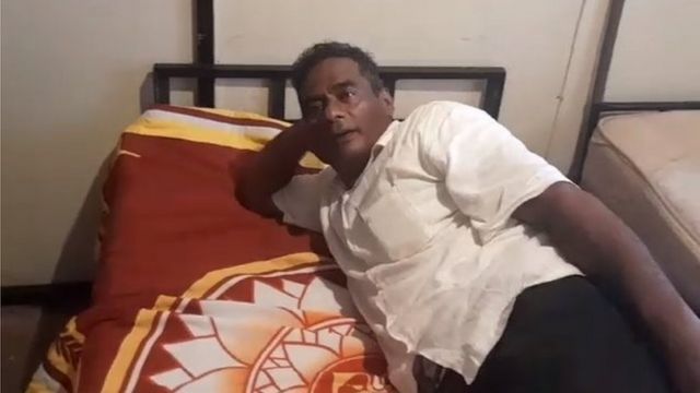 Udeni Kaluthantri,lounges on a bed draped with Gotabaya Rajapaksa's presidential flag