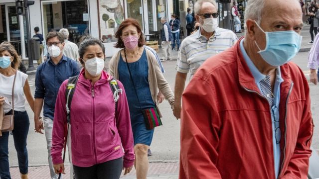 People with masks walking on the street in Madrid