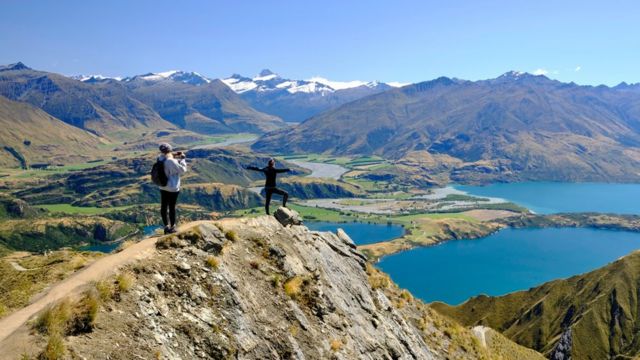 Tourists taking pictures of the views of Lake Wanaka from Roy's peak.