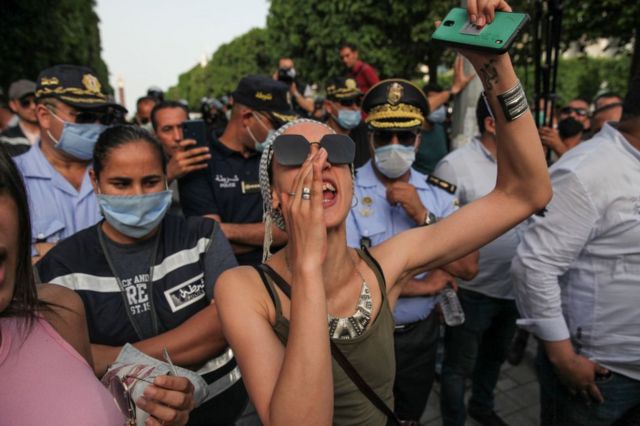 Une femme crie devant un groupe de manifestants en juin 2021.
