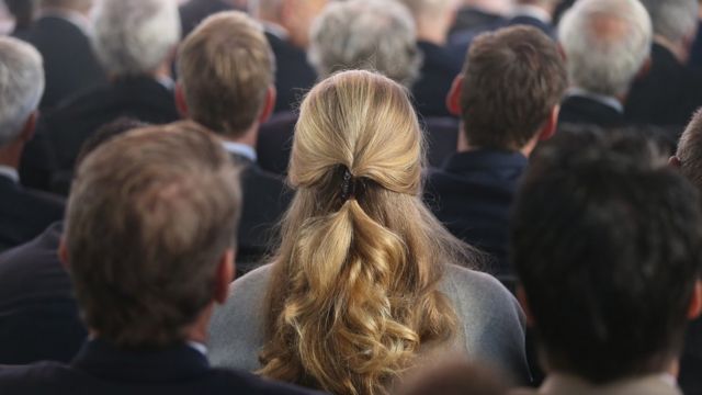 Una mujer rodeada de hombres en una reunión de industriales en Alemania.