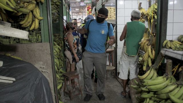 Homem faz dedetização em mercado em Manaus