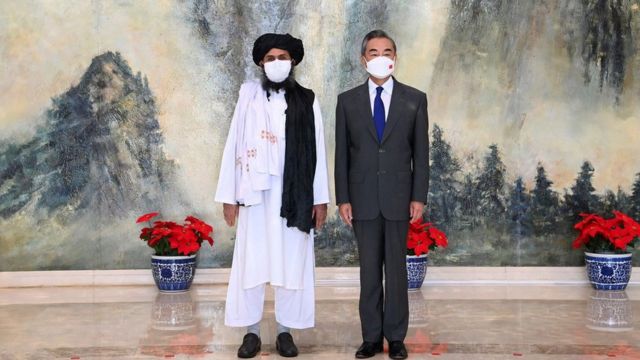 Chinese Foreign Minister Wang Yi (right) and Mullah Abdul Ghani Baradar, head of the Taliban Political Committee in Afghanistan