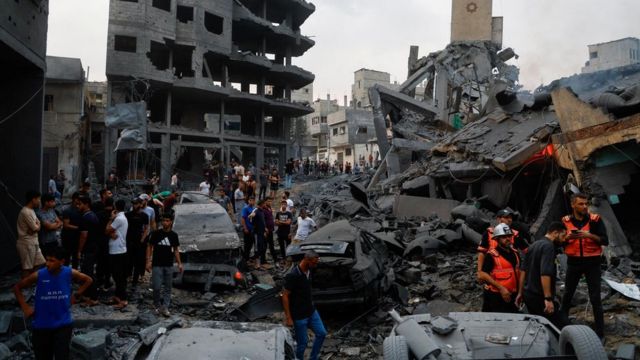 Emergency personnel and Palestinians inspect damages in the aftermath of Israeli strikes, following a Hamas surprise attack, at Beach refugee camp, in Gaza City, October 9, 2023