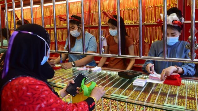 Employees in a gold shop wear hairbands with reindeer antlers as part of Christmas festivities in the southern Thai province of Narathiwat on December 25, 2020.