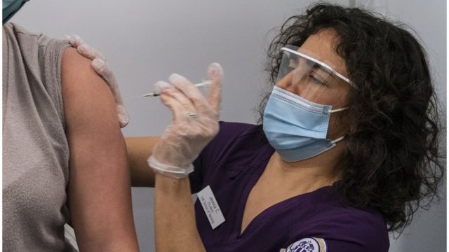 A US medical worker injects a woman with the vaccine