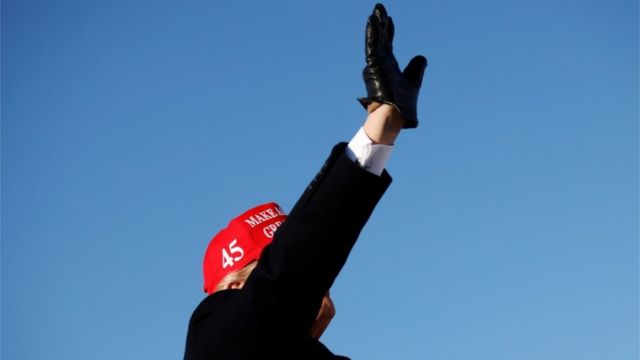 Donald Trump ergue o braço em comício, sob céu azul