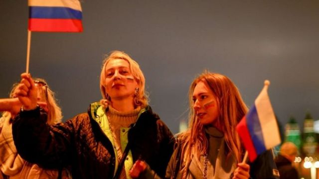 Young woman holding Russian flag.