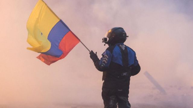 Un manifestante sostiene una bandera de Ecuador en las protestas de 2019.