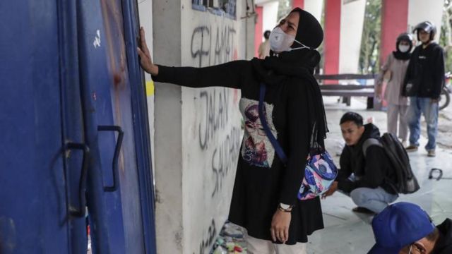 S﻿eorang perempuan menangis di depan pintu Stadion Kanjuruhan, Malang, pada Senin (3/10).