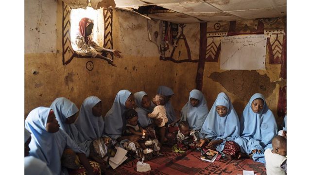 Jóvenes sentadas en el suelo con su túnica azul celeste en el Centro para la Educación de las Niñas, Zaria, Nigeria