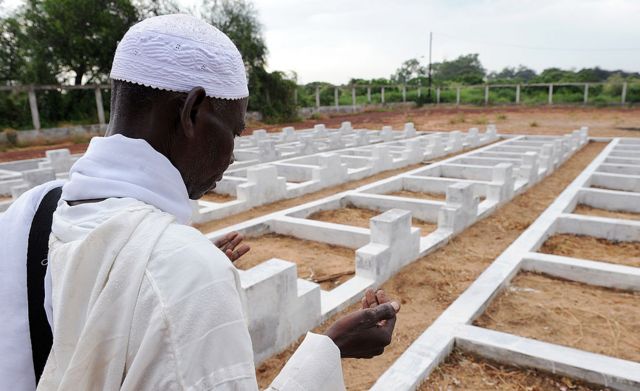 Prières d'un homme au cimetière des naufragés à Mbao.