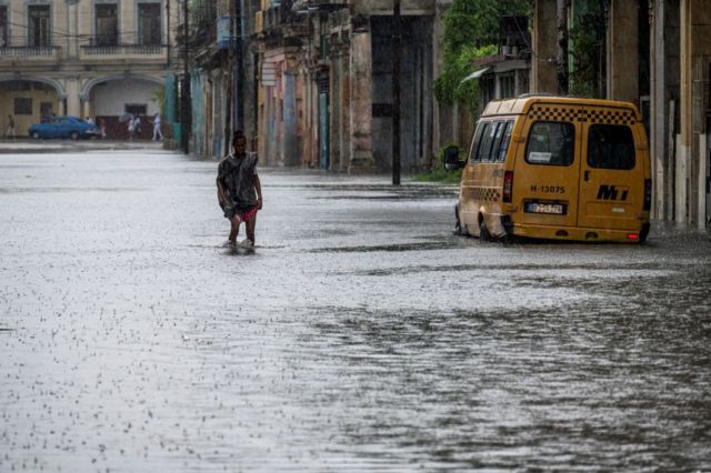 Un hombre camina por una calle inundada en La Habana.