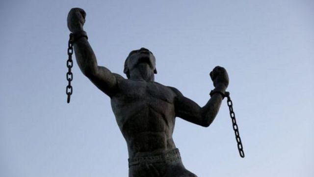 Estátua de homem escravizado, com algemas rompidas