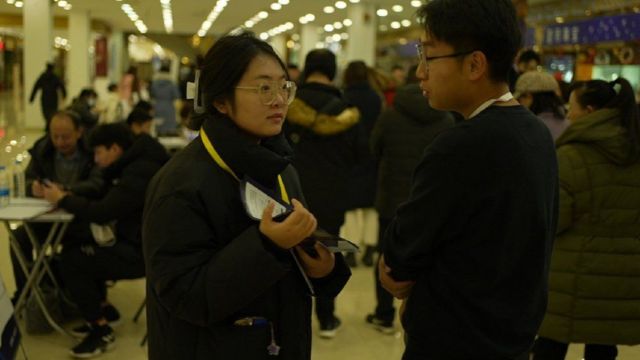 Um homem e uma mulher conversando em uma feira de empregos em Pequim