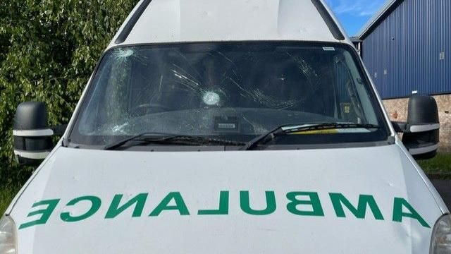 The front of an ambulance with a crack in the middle of the windscreen