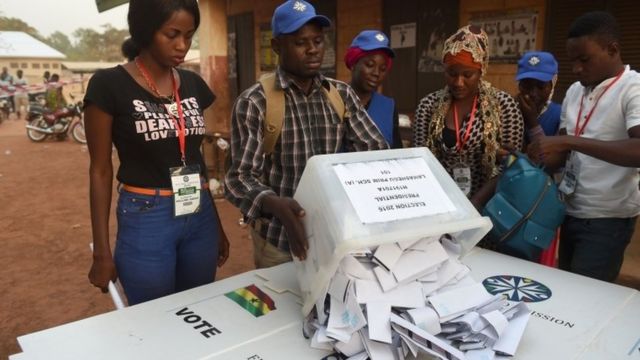 An electoral official overturns a ballot box prior to counting votes at a polling station in Tamale, northern region, on December 7, 2016.