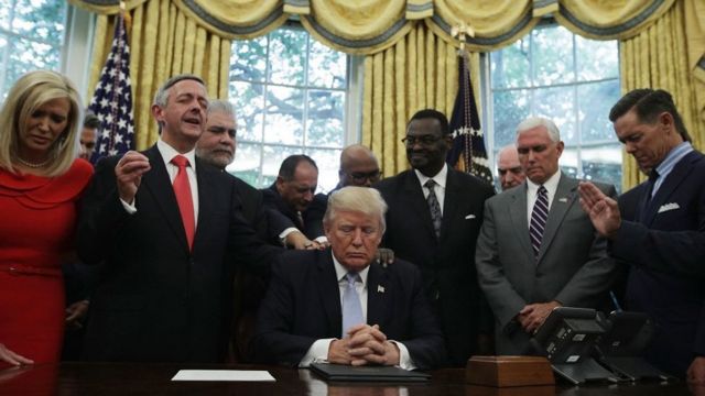 El presidente Donald Trump, el vicepresidente Mike Pence y líderes religiosos rezan en la Oficina Oval.