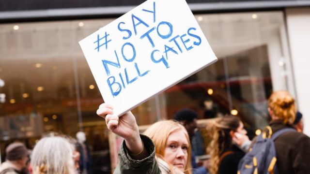 Um ativista em Londres segura uma placa com os dizeres 'Diga não a Bill Gates'