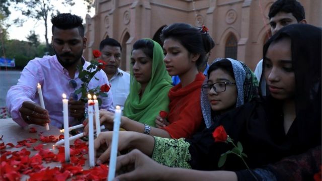 Personas encienden velas