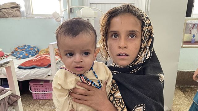 فتاة تحمل طفلًا يتلقى العلاج الطبي في مستشفى مير فيز في قندهار ، أفغانستان، 28 أكتوبر/تشرين الأول 2021