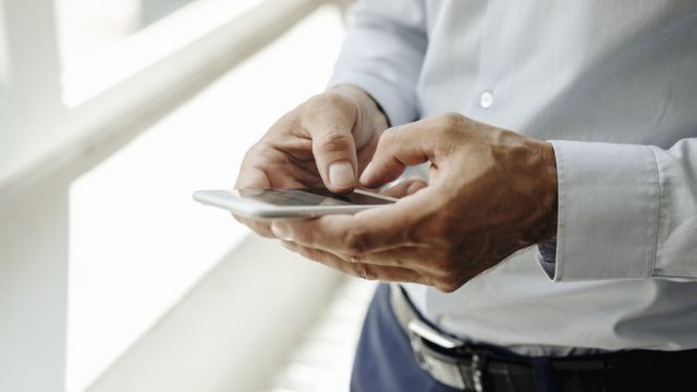 Hombre escribiendo en un teléfono