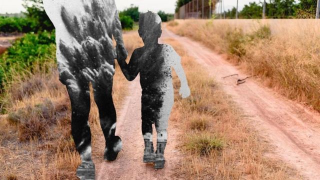 Criança de mão dada com um adulto