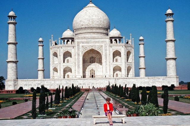 Diana, Princess of Wales, wearing a red and purple suit designed by Katherine Walker, poses alone outside the Taj Mahal in Agra, India, February 11, 1992.