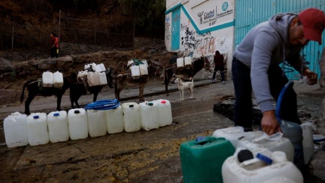 Residente de Xochimilco, en Ciudad de México, rellena botellones de agua el 20 de abril del 2021